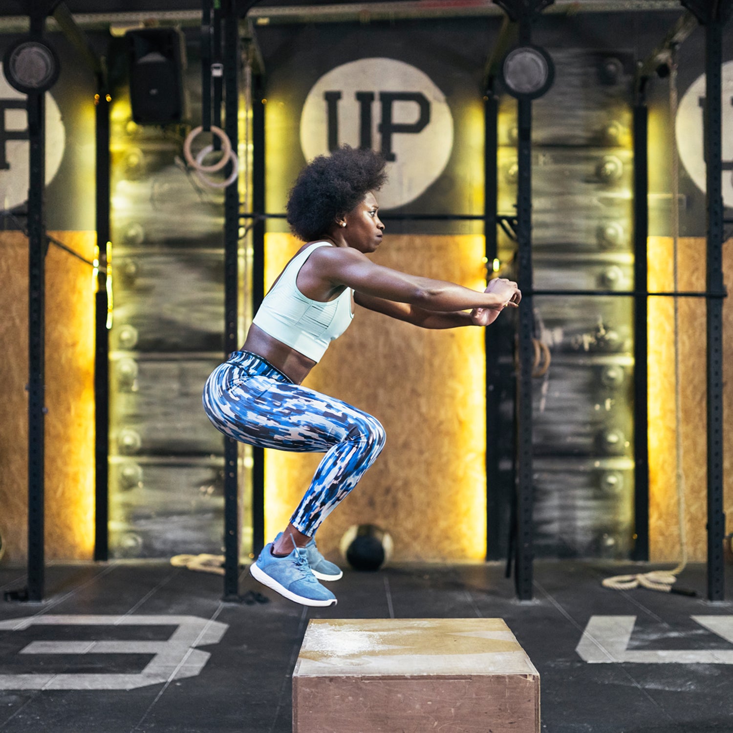 Side View Of Sportive Woman Jumping At Gym