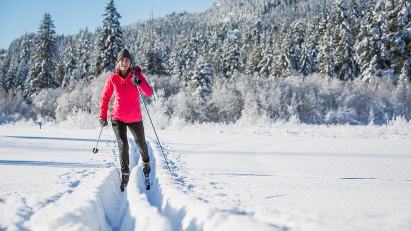 Woman cross country skiing on sunny day.