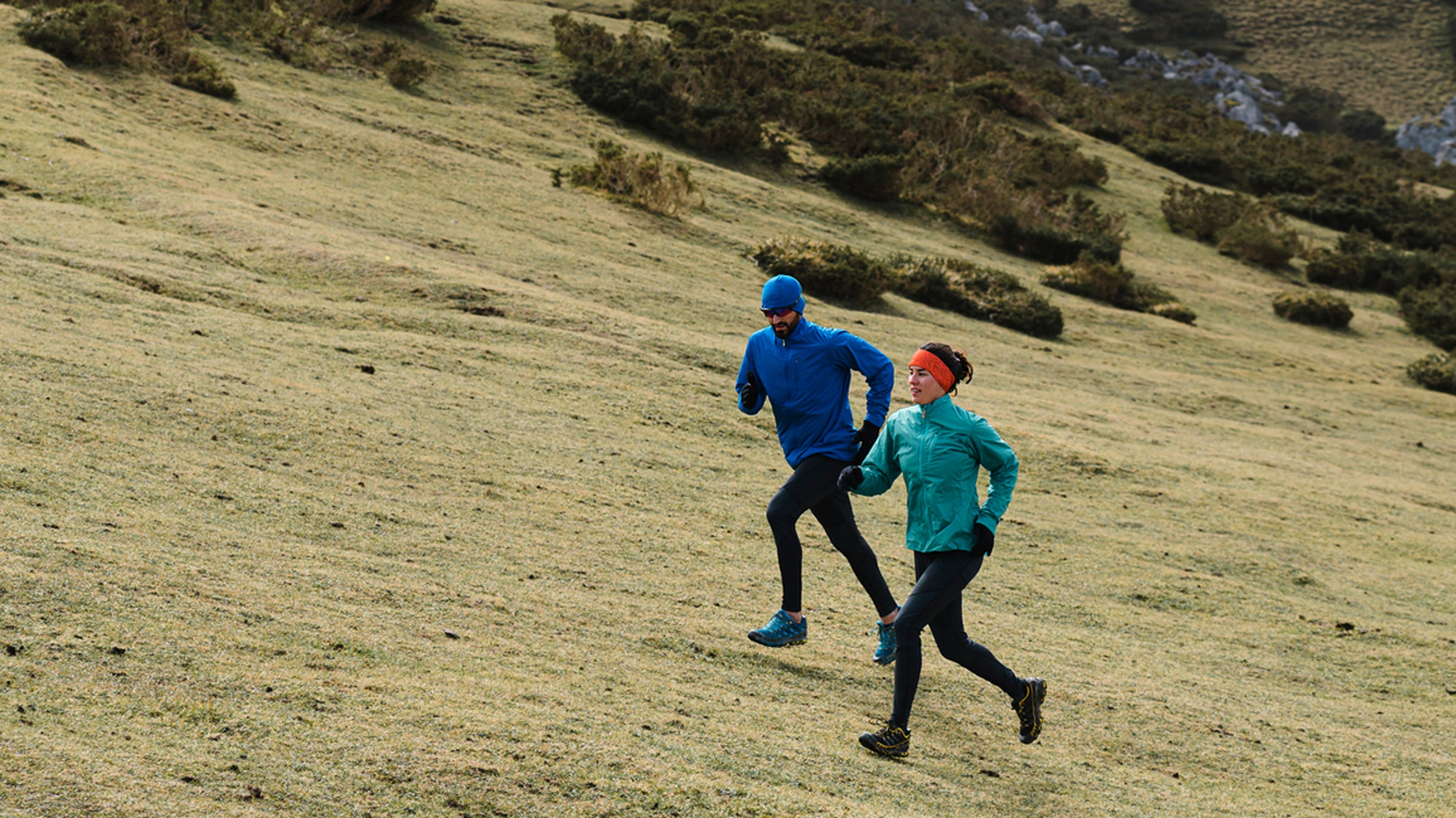 Multi Generational Friends Running Uphill In Mountain Scenery