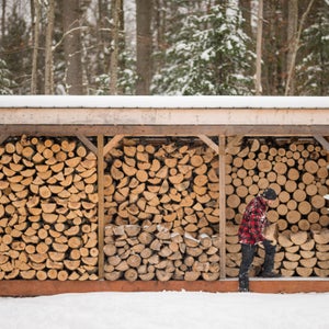 Man With Flannel Jacket Stacking Wood At Cottage Winter Wood Pile