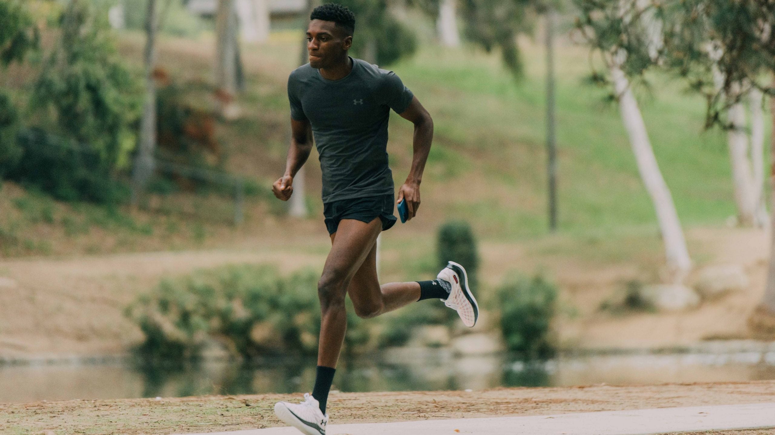 Above, Obi Nwankwo wears Under Armour's UA Flow Velociti Wind (running shoes), UA Vanish Seamless Run Short Sleeve (top), and UA Draft Run (shorts).
