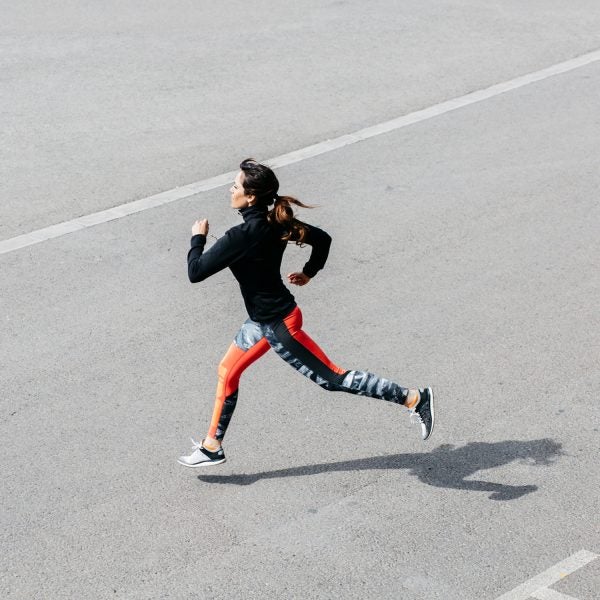 Side View Of Young Brunette Sportswoman Running