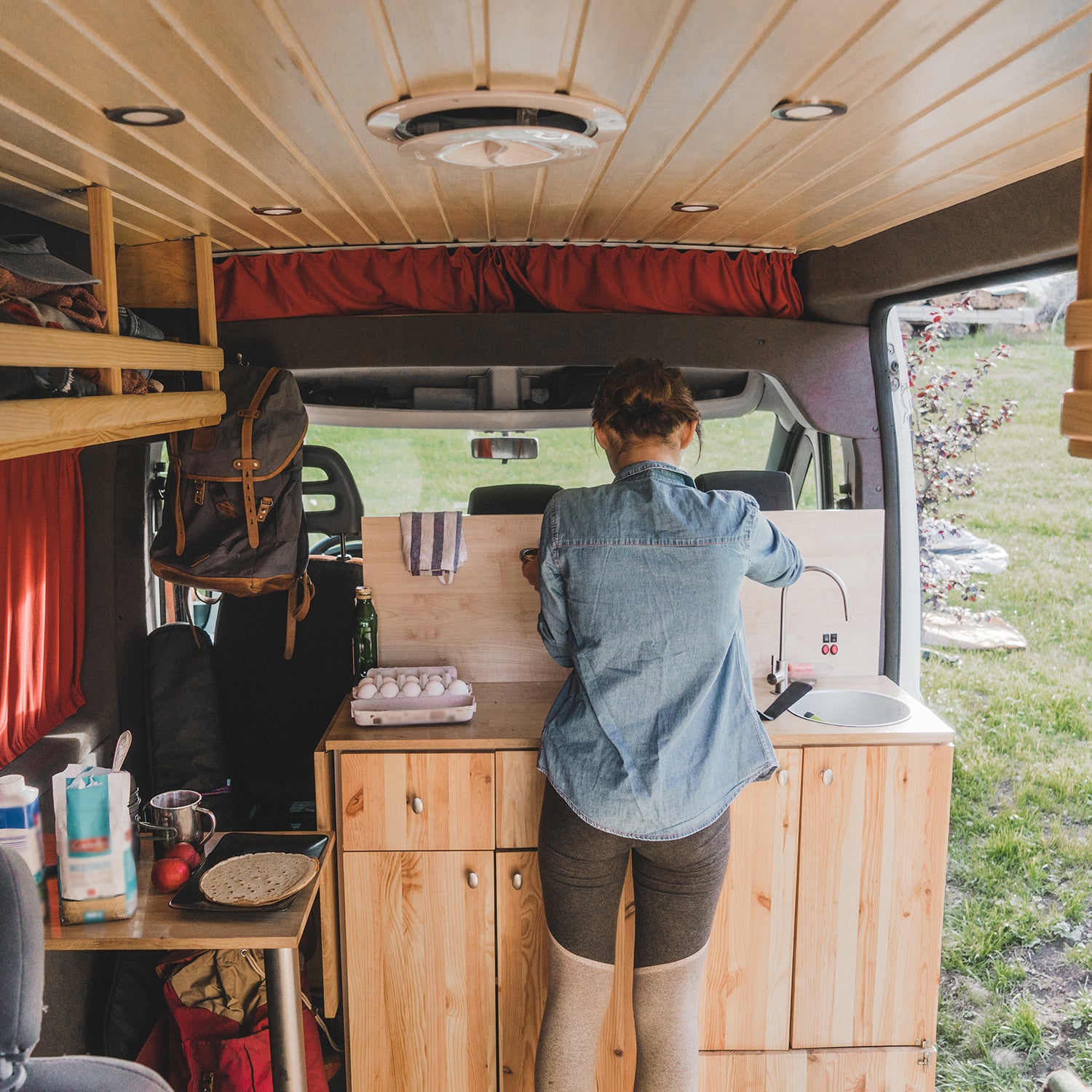 Woman cooking pancakes in camper van