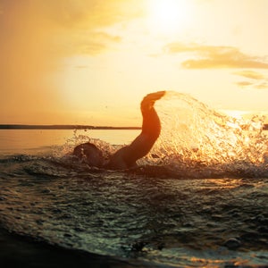 Swimmer conducts training in a lake at sunset