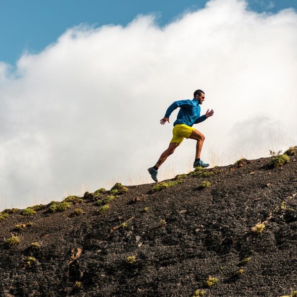 Sportsman Running In Mountains On Foggy Day
