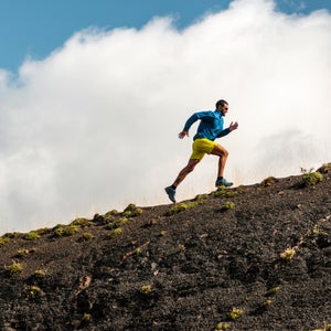 Sportsman Running In Mountains On Foggy Day