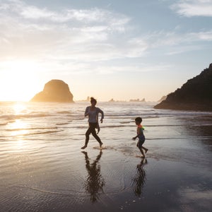 Mom Playing With Kid At The Beach.