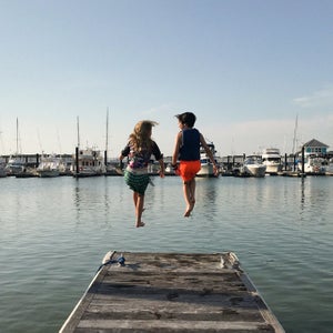 Evie Neville, left, and her cousin, Beckett Neville, take the leap into the warm, saltwater of Kings Creek Marina near the mouth of the Chesapeake in Cape Charles, Va.