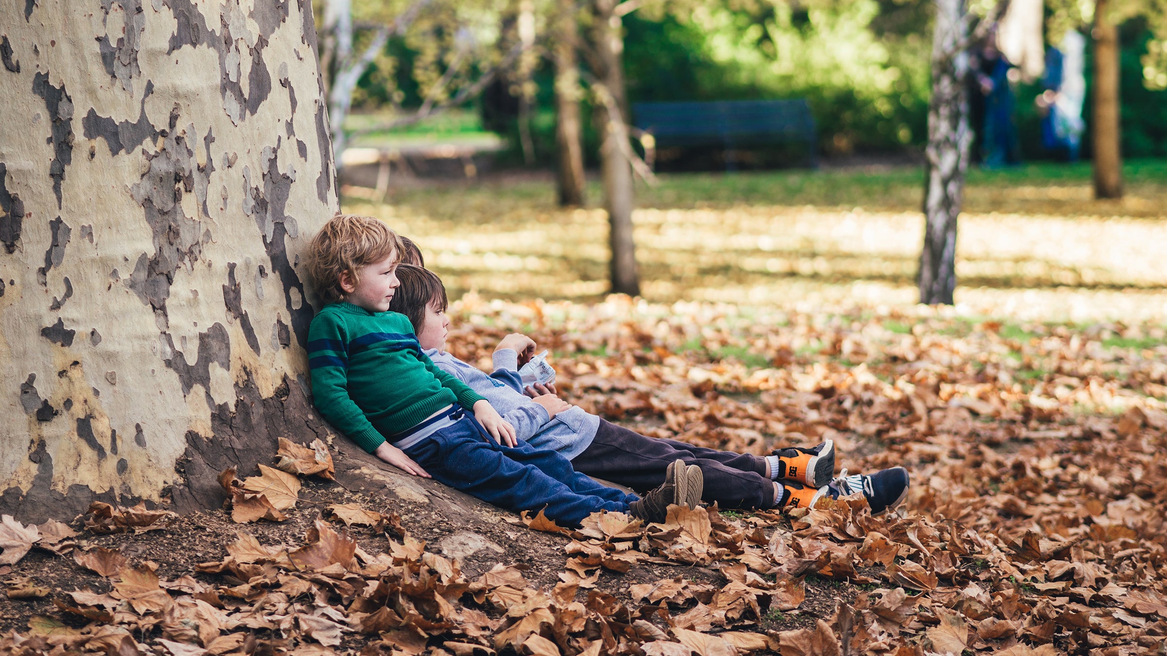 Kids leaning on tree