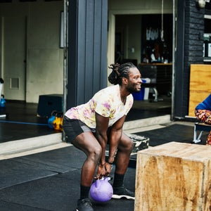 Man doing kettlebell squats during workout at outdoor gym
