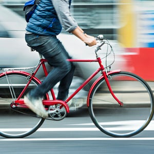 Person cycling on red bicycle in street