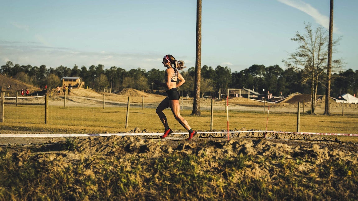 Woman running in summer on grassy feild.