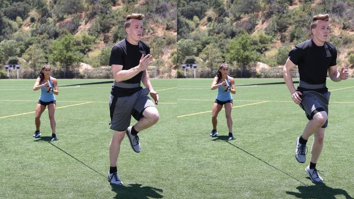 Man running in place while woman holds resistance behind him
