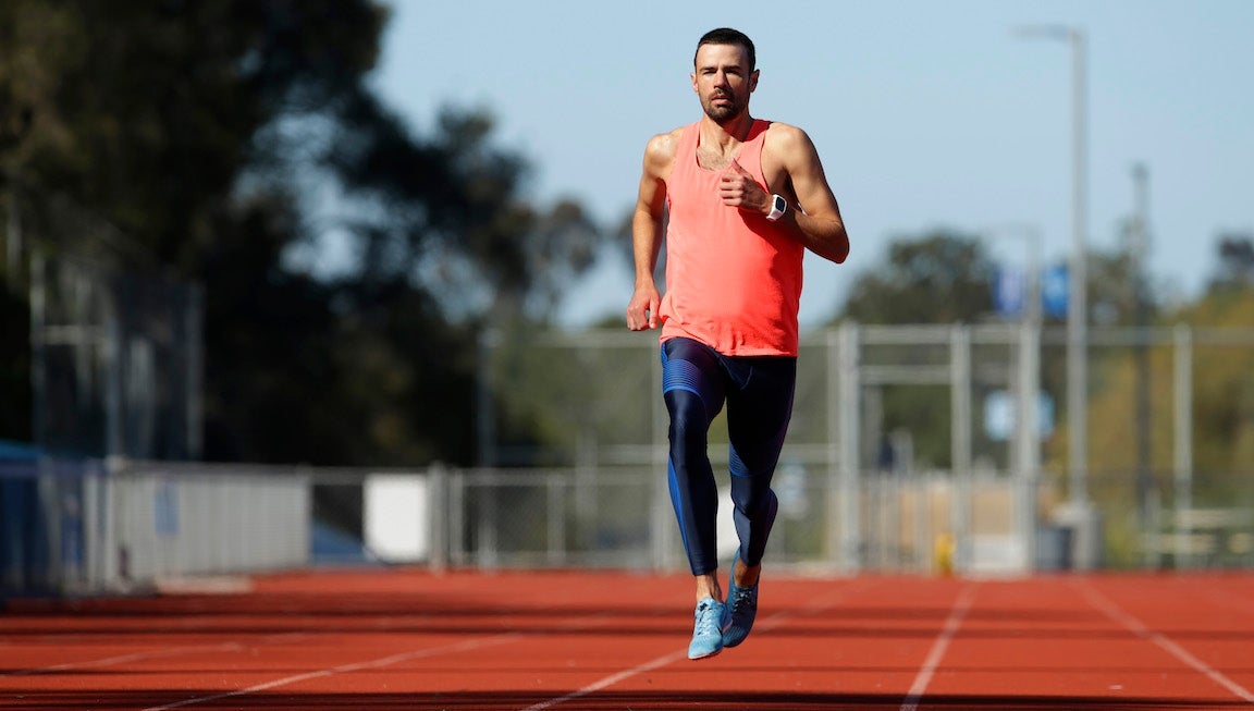 A male runner trains on a track on a sunny day in San Diego, California.