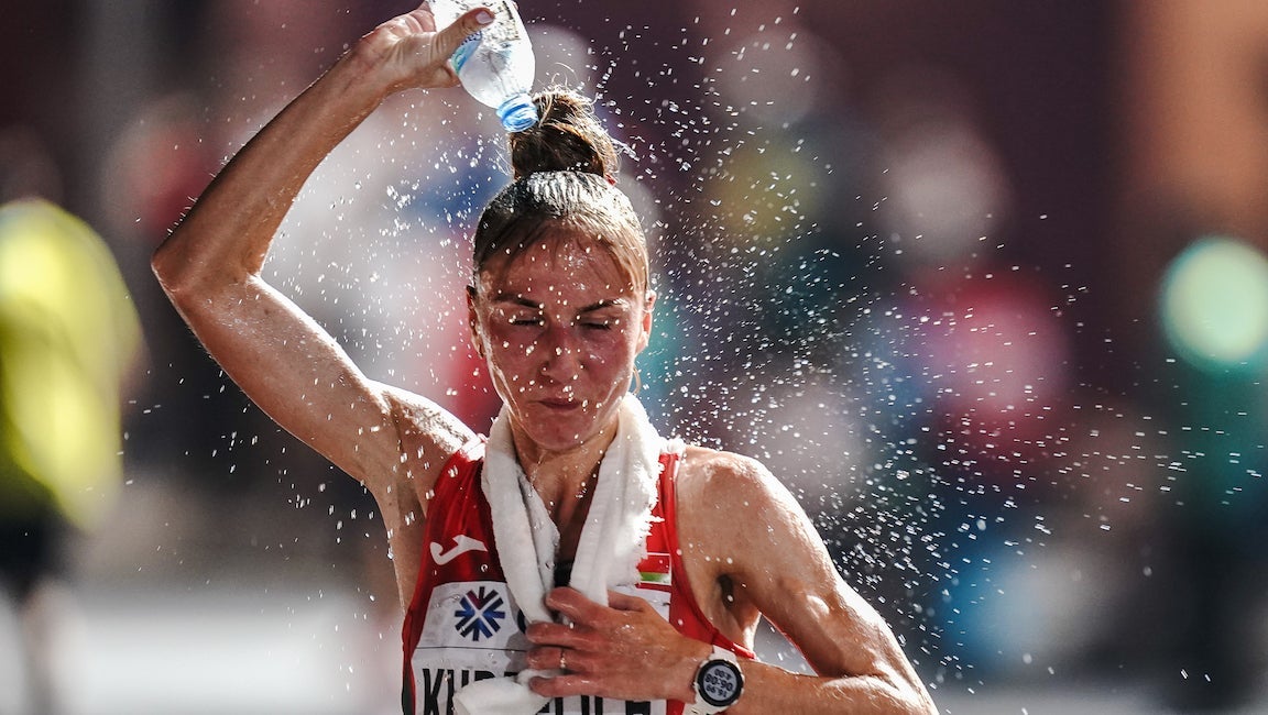 Woman pours water over her head during a race.