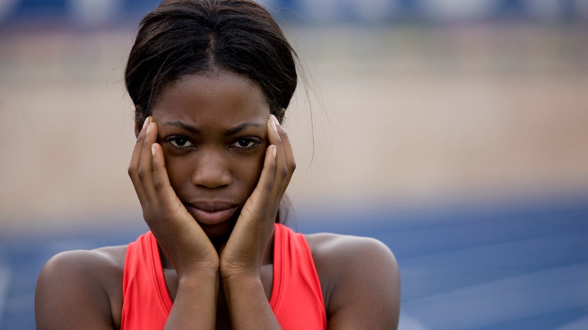 Close-up of female track athlete with hands on cheeks looking super nervous like she might be suffering from pre-race anxiety.