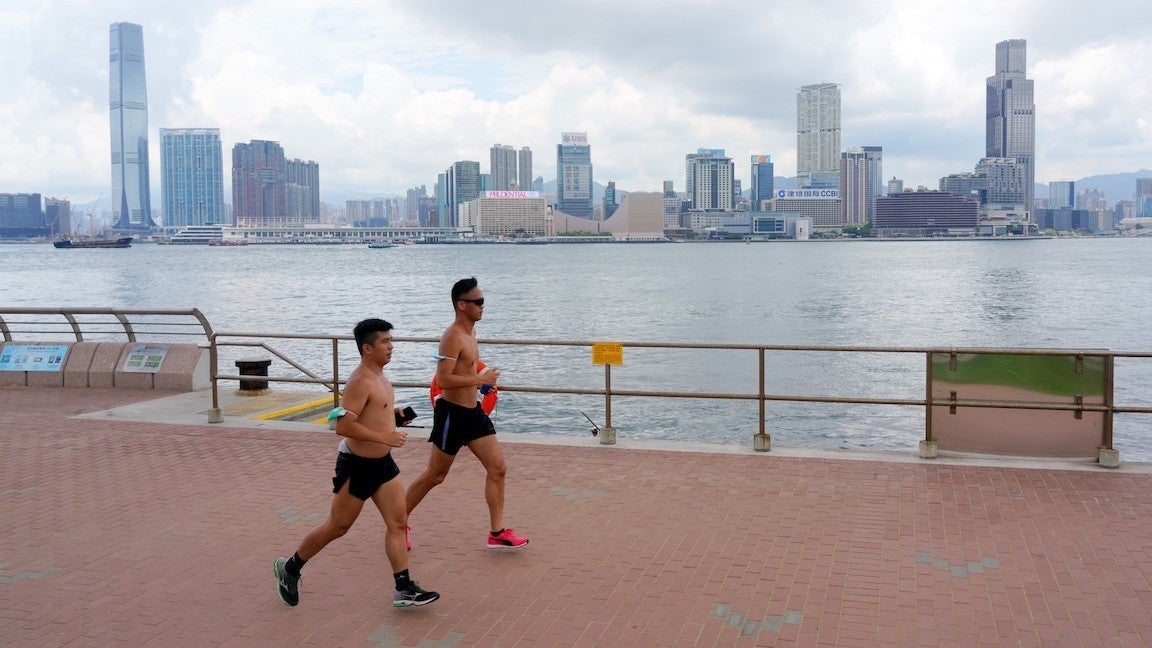 Two men running in the heat in Hong Kong.