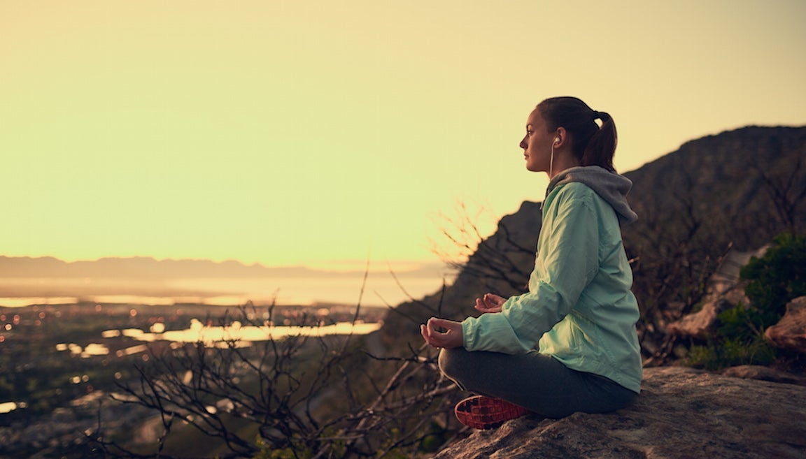 Woman meditating outdoors.