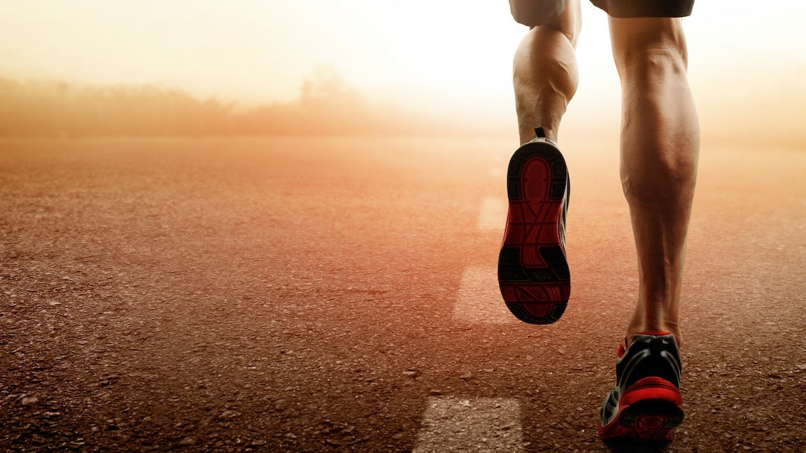 Stock images of man running (just calfs down) into a hazy sunset.