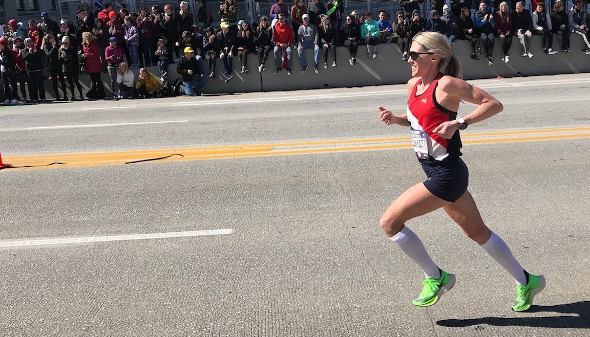 Woman running on road in race.