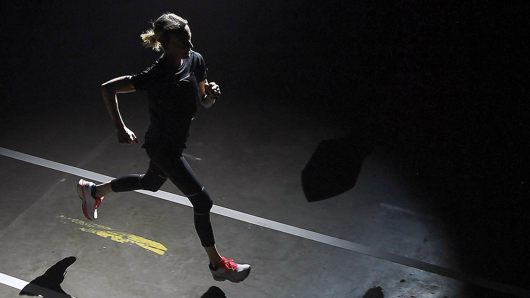 Woman runs in the dark on a road