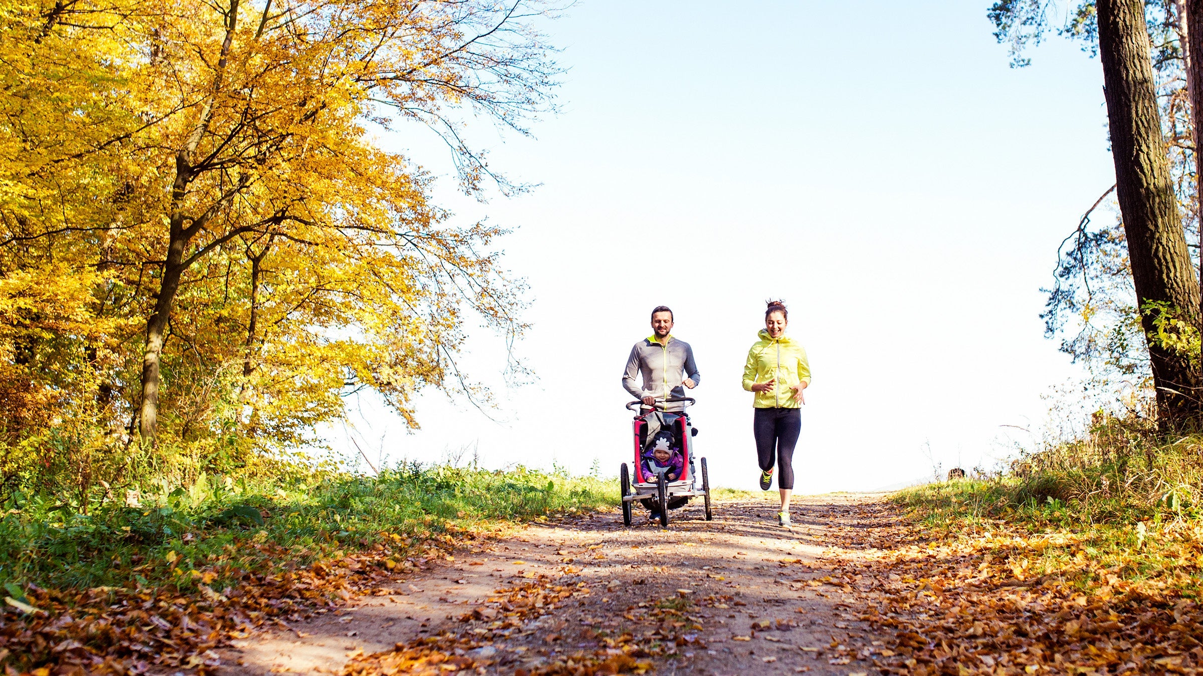 couple running with baby stroller