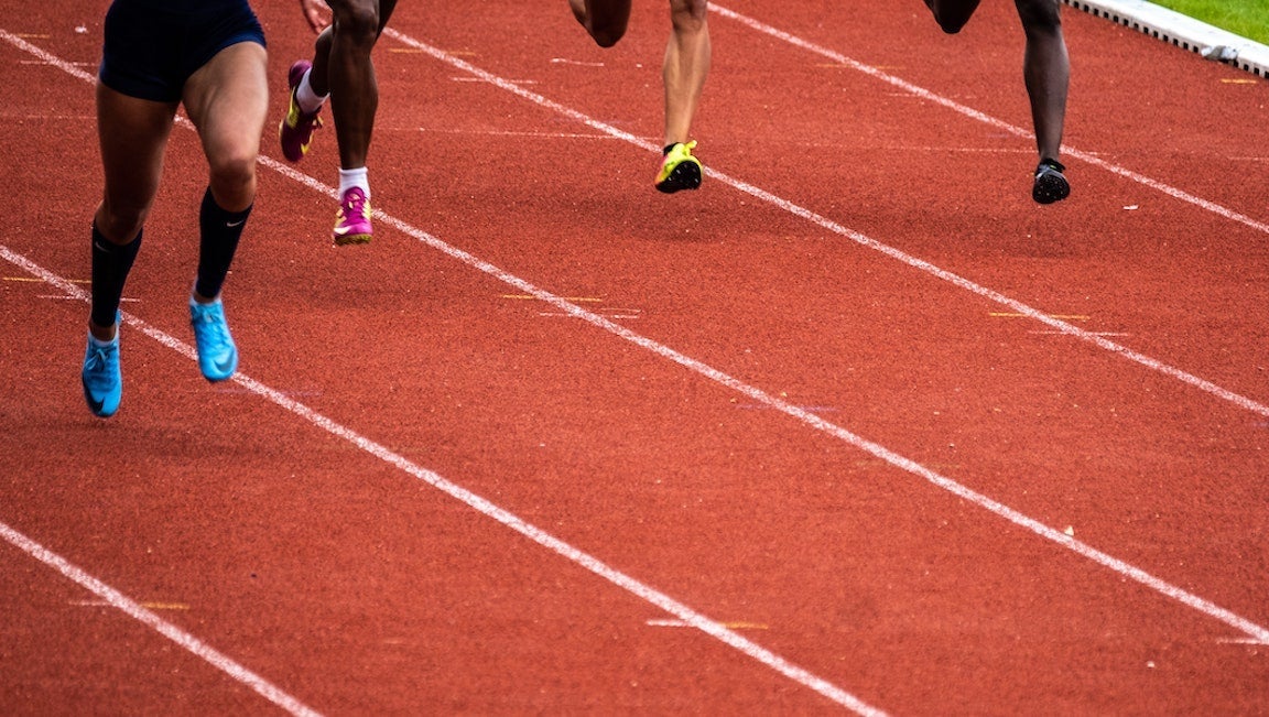 Legs of people racing on a track.