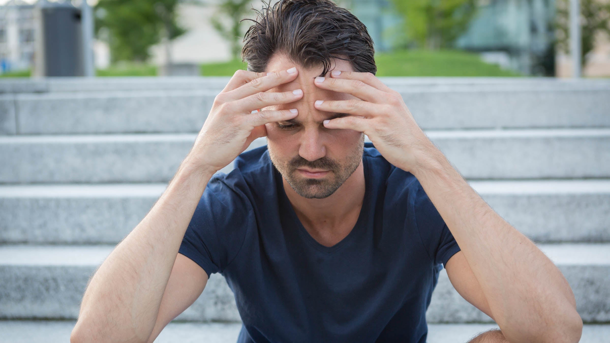 Athlete sitting on stairs with hands on head