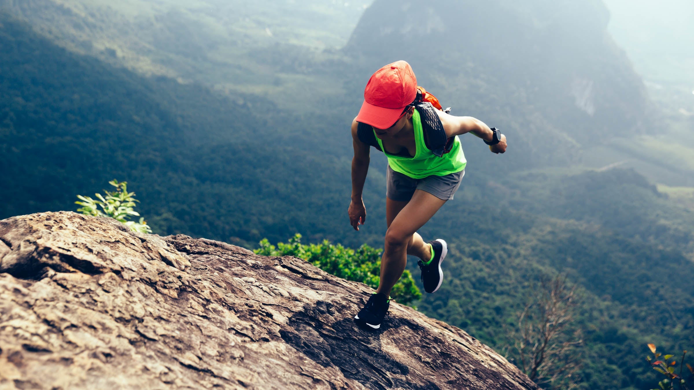 Young woman running up to the mountain top