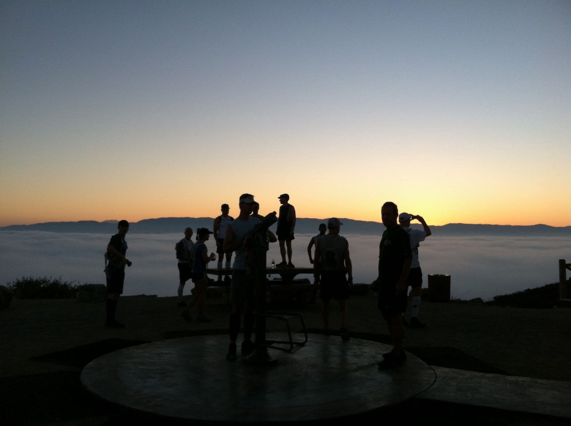 Runners on a hill at the crack of dawn.