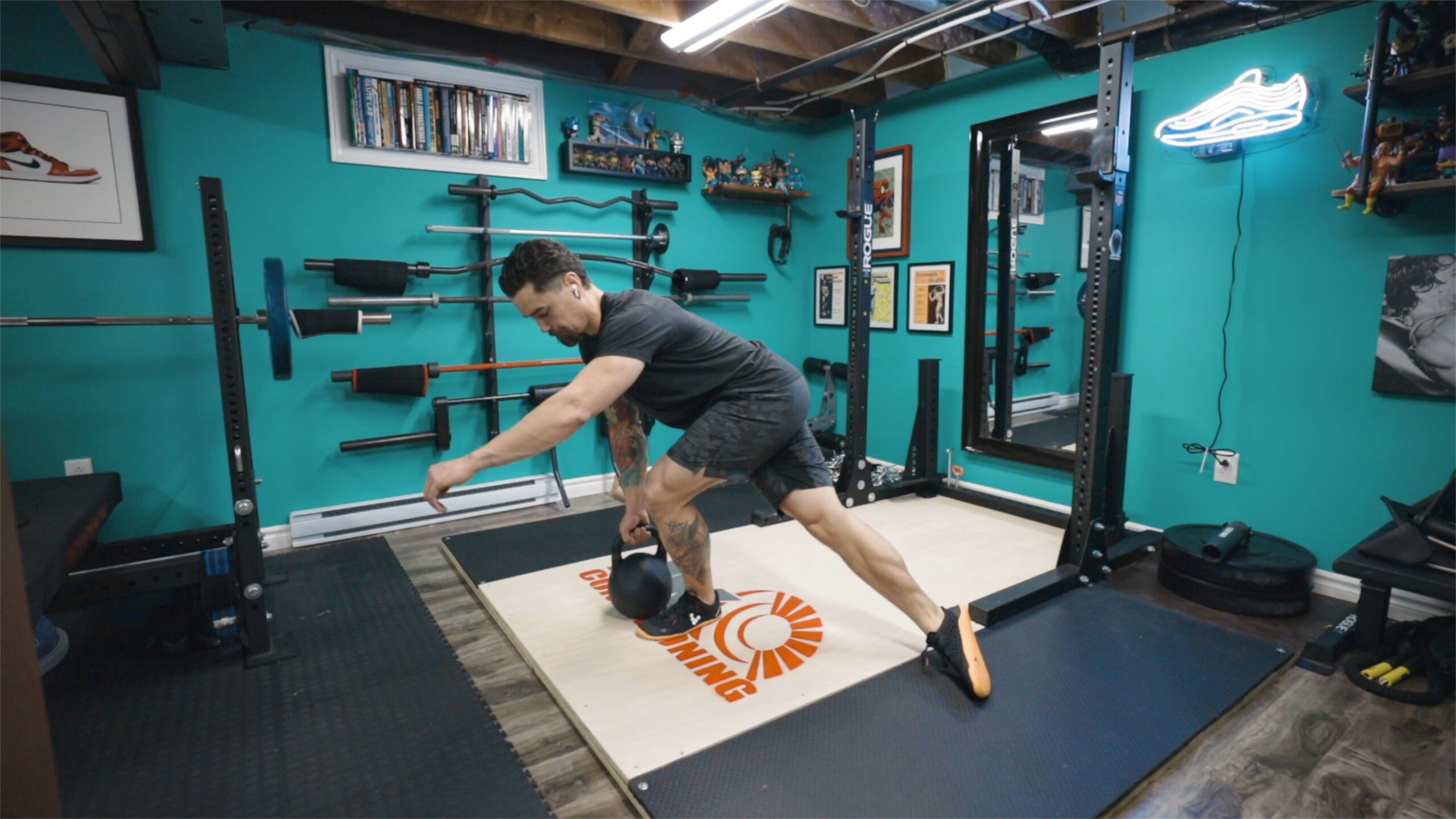 Man crossing right leg over in back while balancing on left leg with kettlebell.