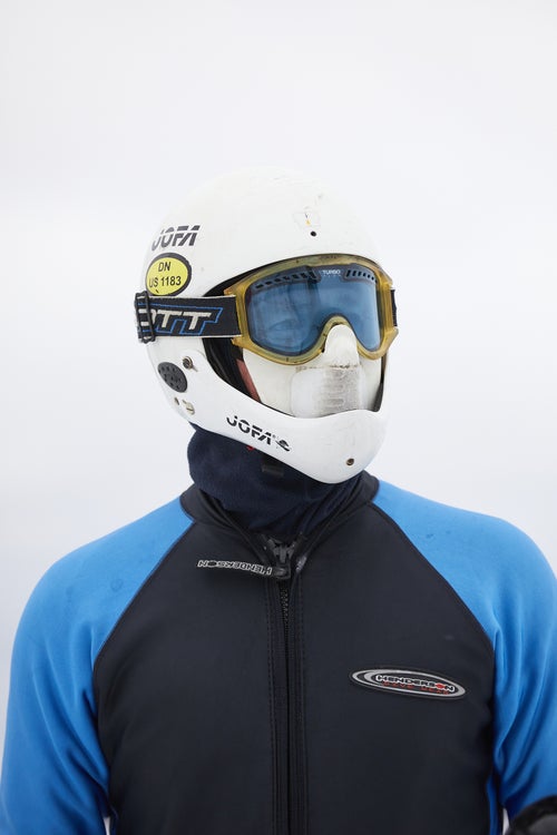 An iceboat racer wearing a protective facemask and bodysuit.