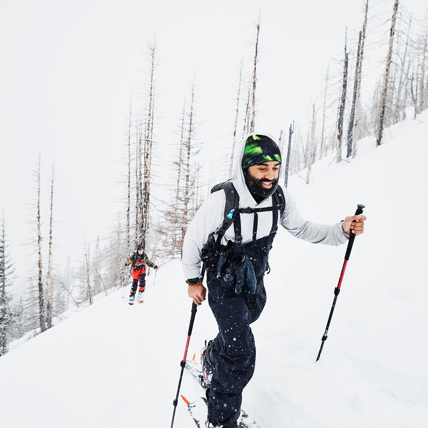 Friends touring on splitboards on snowy winter morning
