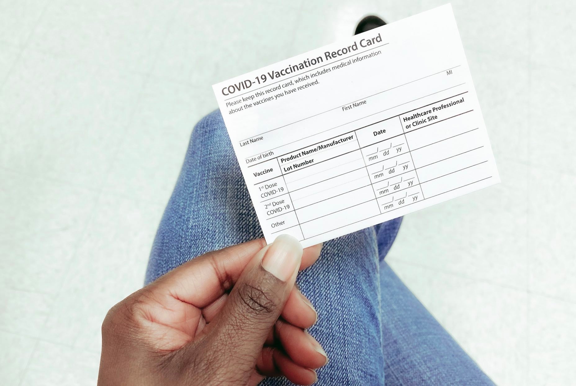 Hand holding Covid vaccination card