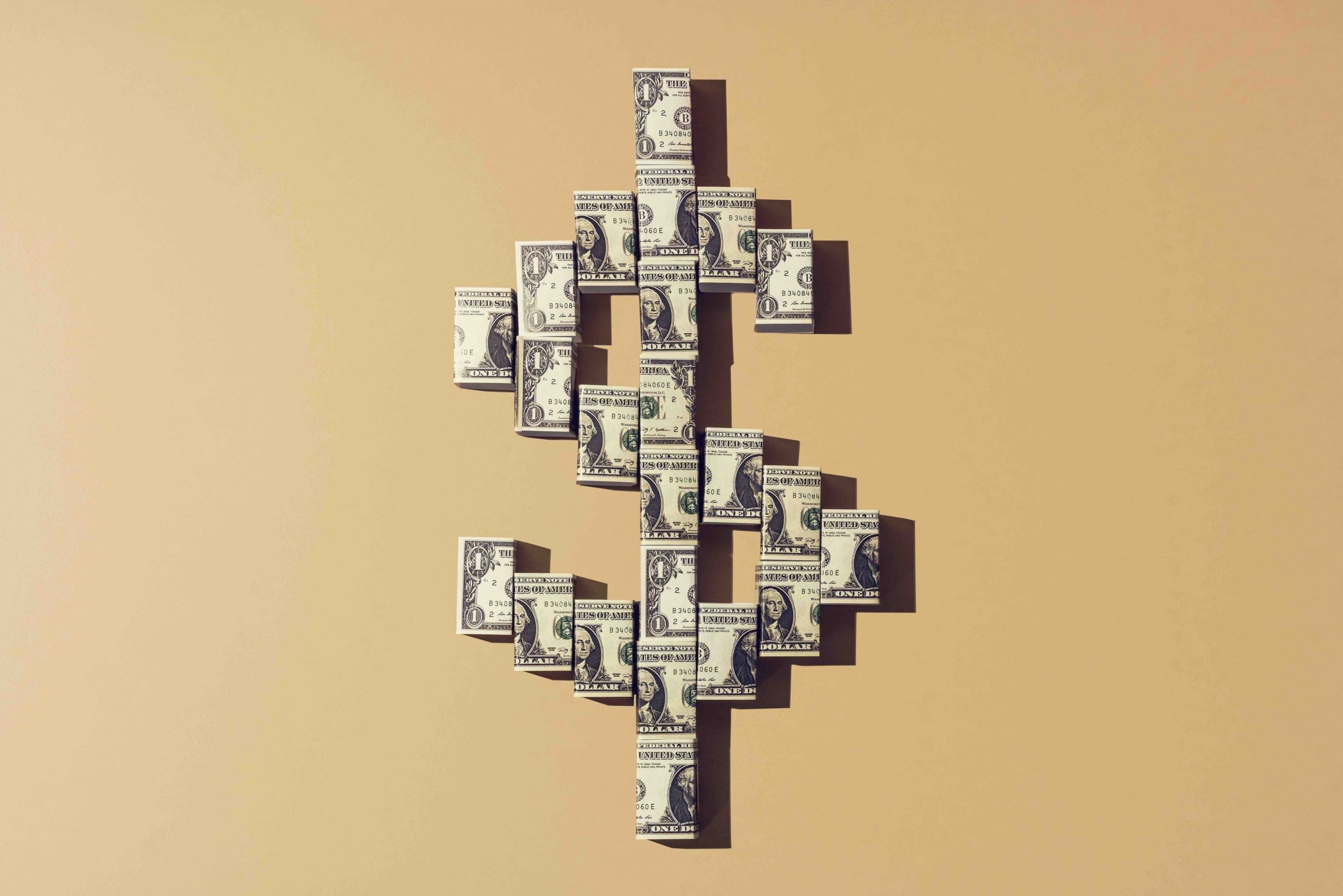Still life of folded american dollar notes making a shape of the dollar currency sign