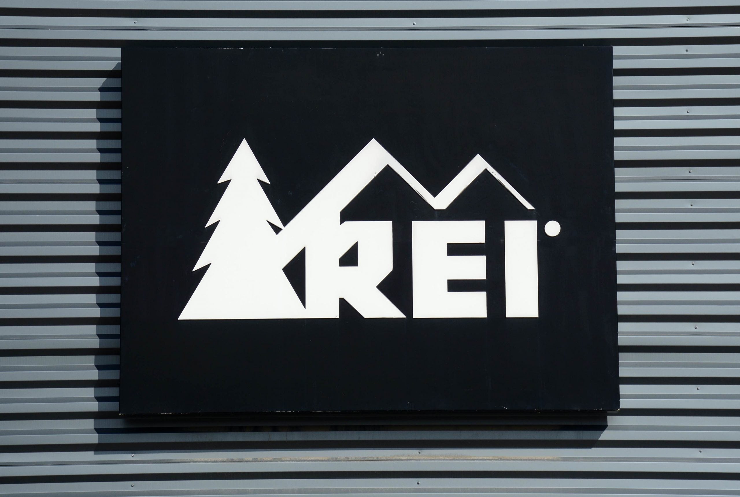 REI sign hanging on a metal wall