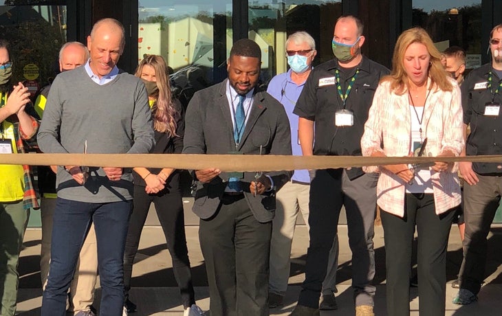 Three people cutting a ribbon during the grand opening of Public Lands