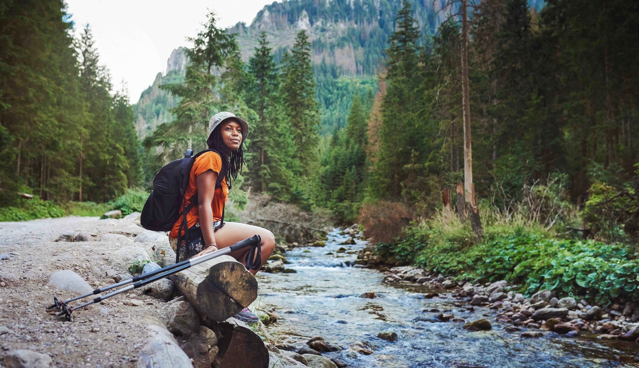 Woman sitting on a rock by a river