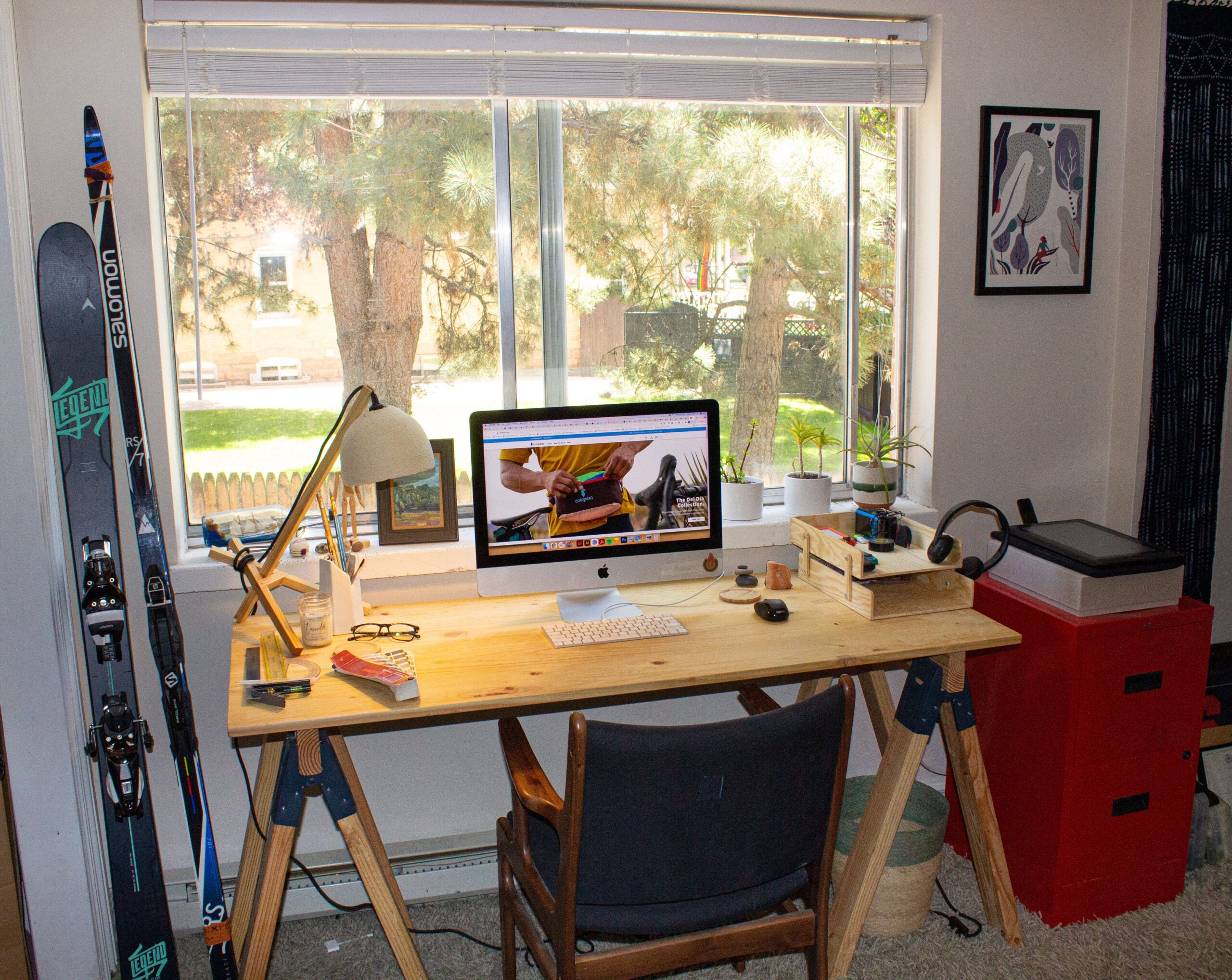 Home office for remote work with wooden desk an computer set in front of a window