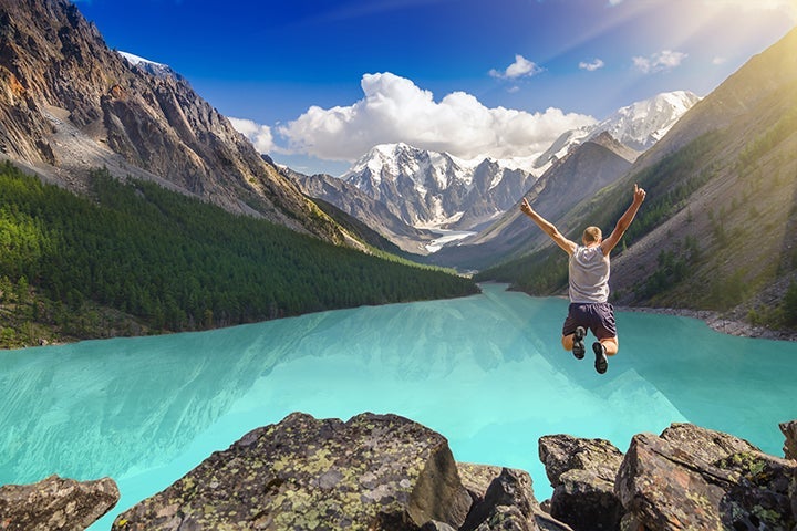 Beautiful mountain landscape with lake and jumping man None