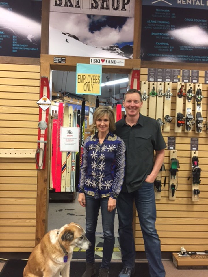 dunbars A man and woman with a dog in retail store with ski bindings and employee entrance on back wall. Neptune Mountaineering