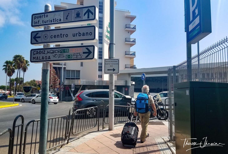 Man walking on street hauling luggage in Spain