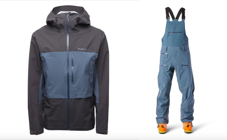 Flylow Kane Jacket and smythe bib Flylow's Kane Jacket sits on the left. It's both dark blue and faded mid-blue. The Smythe Bib sits on the right with orange ski boots.