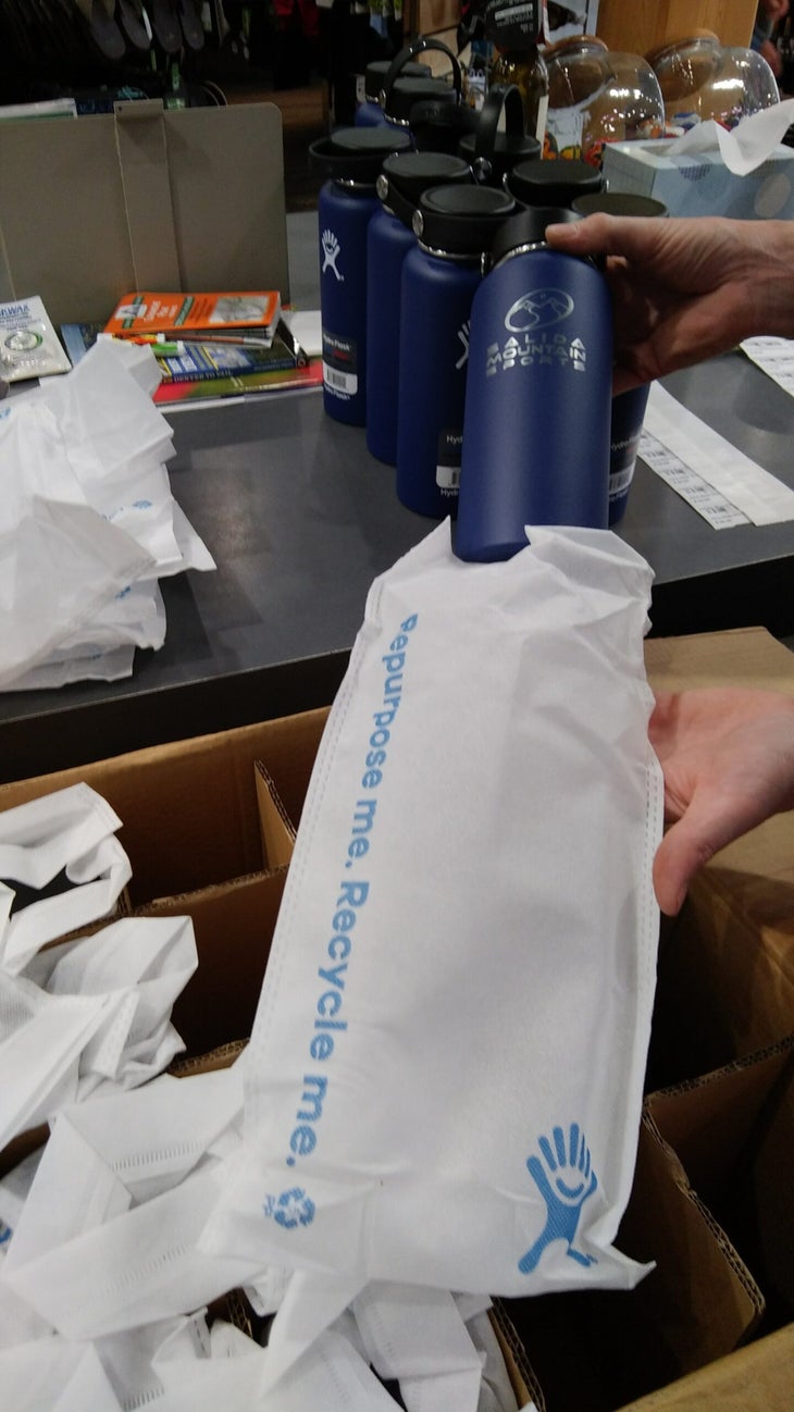 hydro flask reusable bags Hydro Flask blue bottle being removed from reusable bag, a good example of sustainable packaging