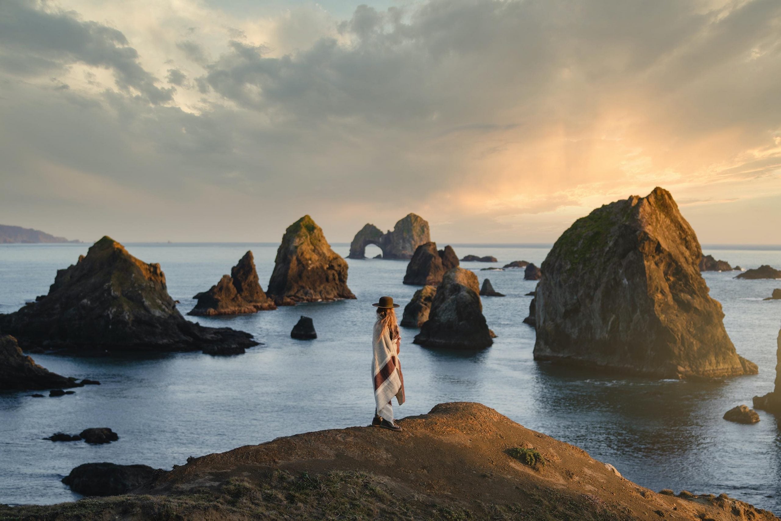 Woman standing in Ibex garment by the ocean