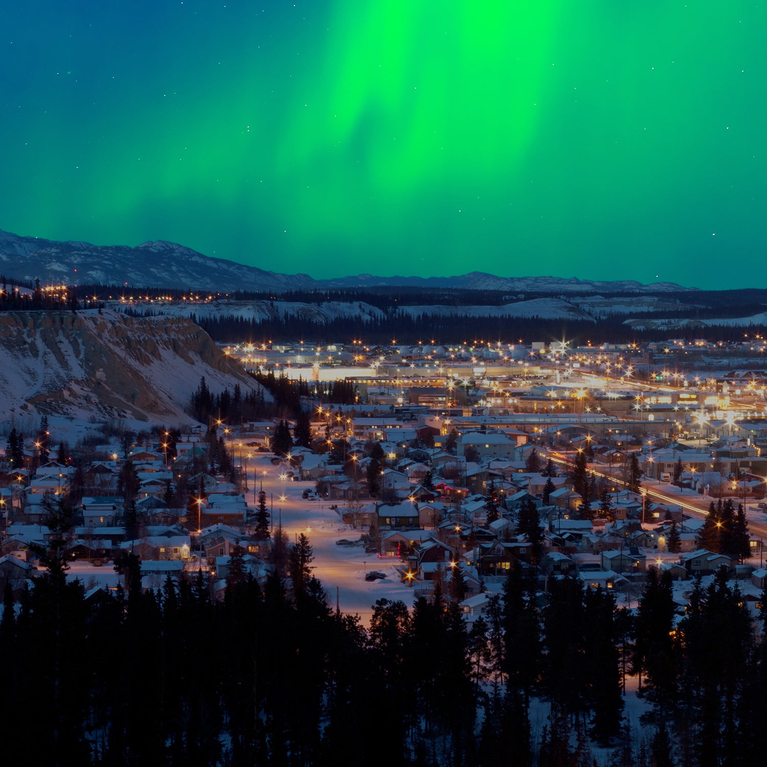 Strong northern lights (Aurora borealis) substorm on night sky over downtown Whitehorse, capital of the Yukon Territory, Canada, in winter.