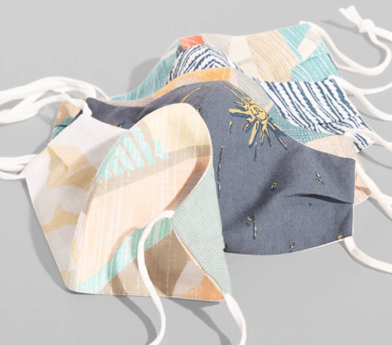 "Colorful prAna face masks fanned out on gray table"