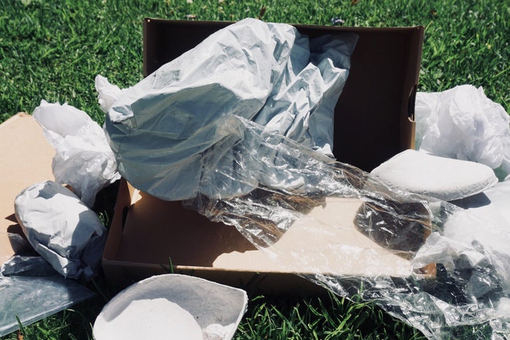 Salabert-Packaging05 A pile of paper, plastic, and cardboard litter the grass in a display of wasteful packaging that is not sustainable.