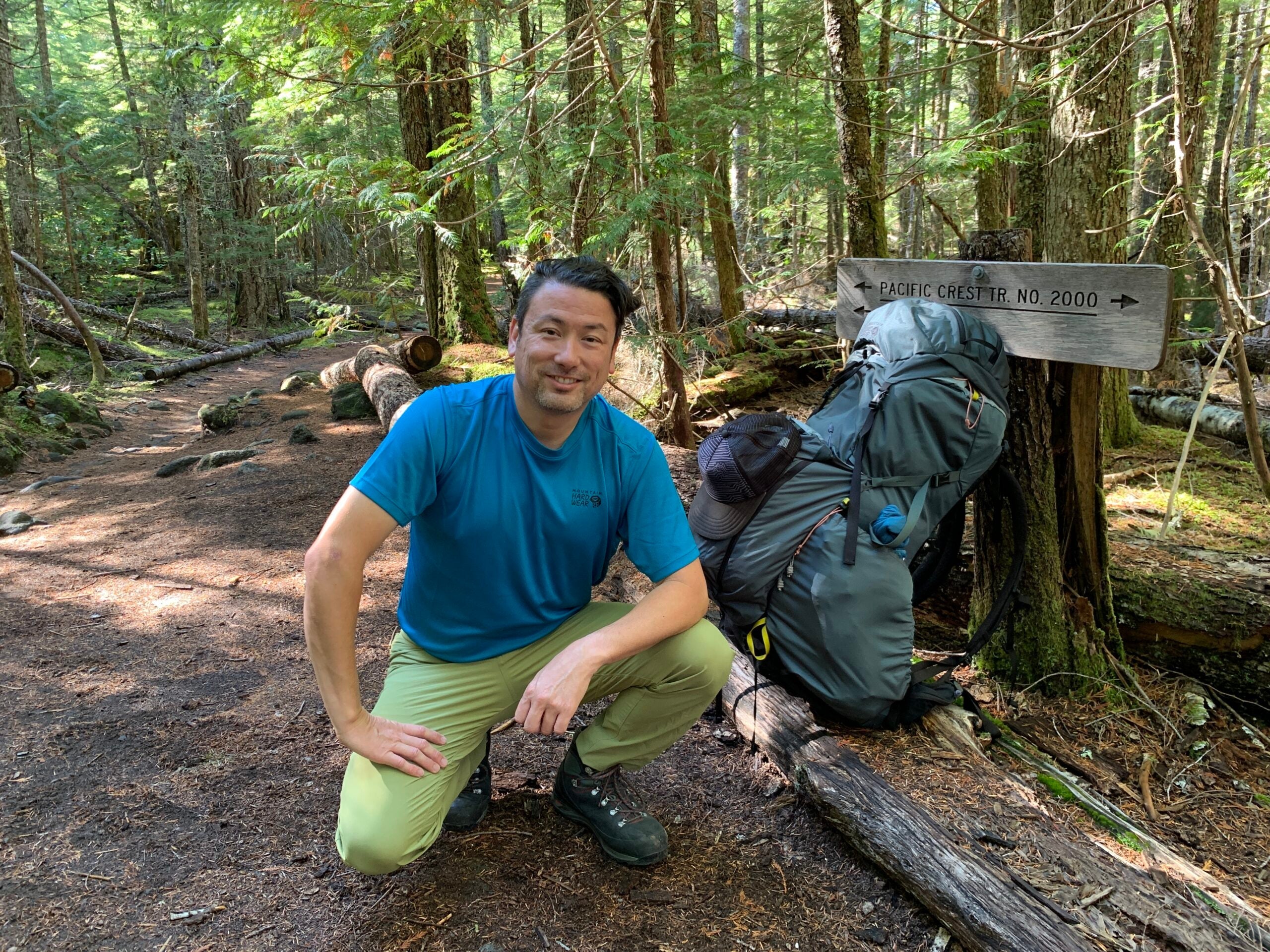 Troy Sicotte of Mountain Hardwear kneeling on the trail in a blue shirt