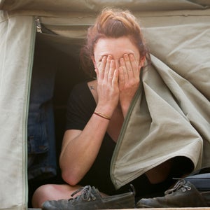A woman waking up in a tent after insomnia camping